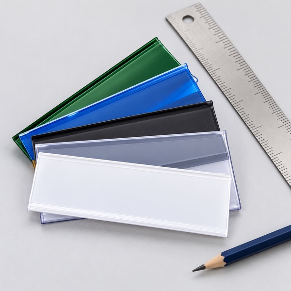Coloured shelf label holders beside a measurement ruler
