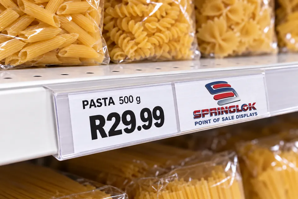 Clear shelf-edge price strip displaying PASTA 500 g at R29.99 beside a white Springlok Point of Sale Displays label